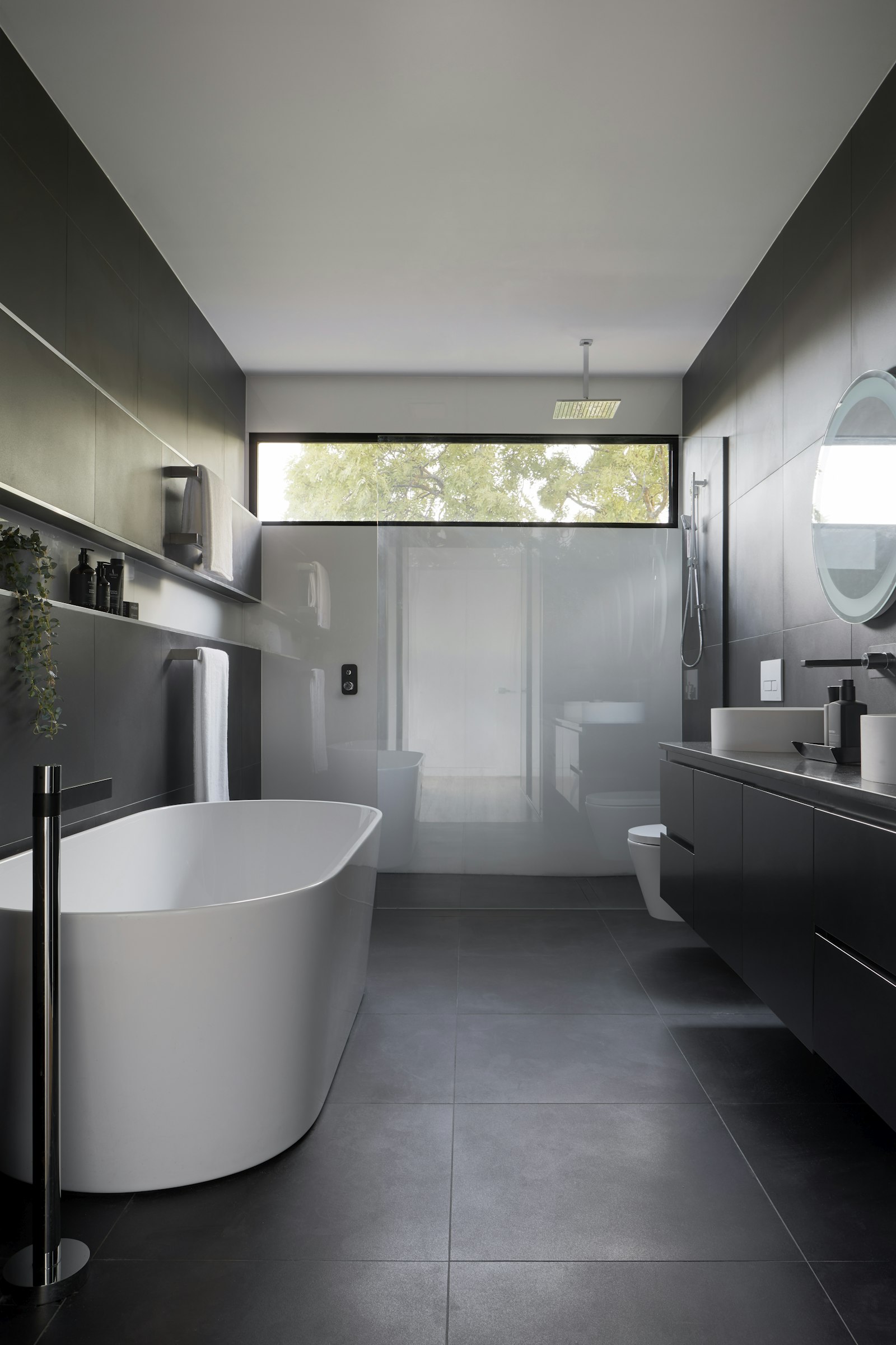 Salle d’eau en grand format anthracite, baignoire et douche
